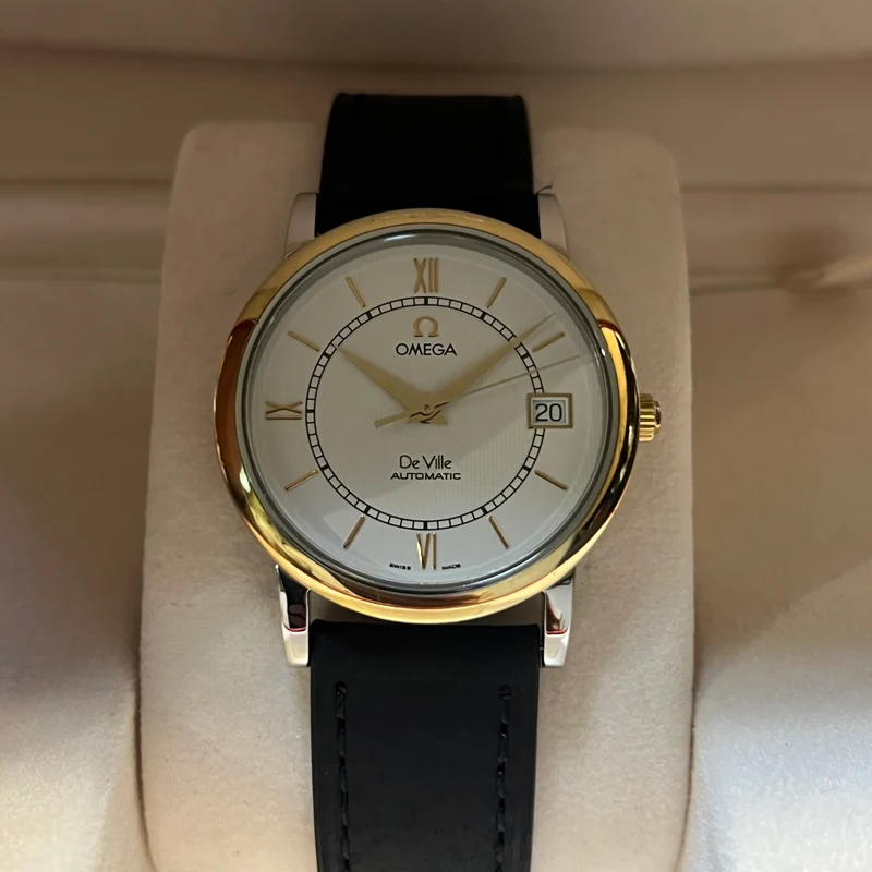 Omega Montre automatique De Ville à lunette dorée, ensemble complet 7704.21.01